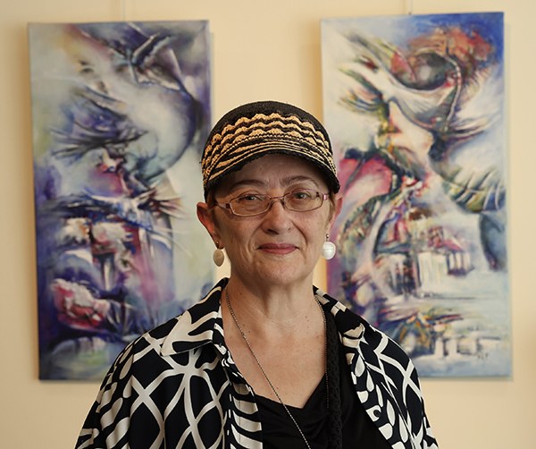 Mª Ángeles Lozano junto a dos de sus pinturas