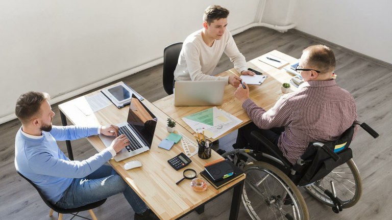 Grupo de personas trabajando, una de ellas con discapacidad