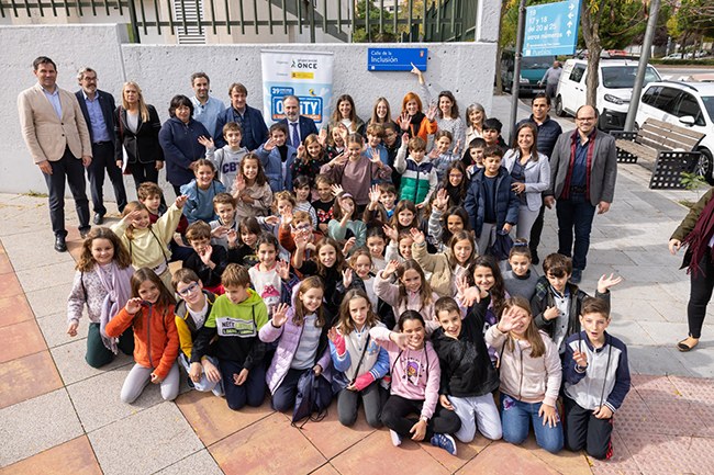 Foto de familia de los chavales y autoridades junto a la placa
