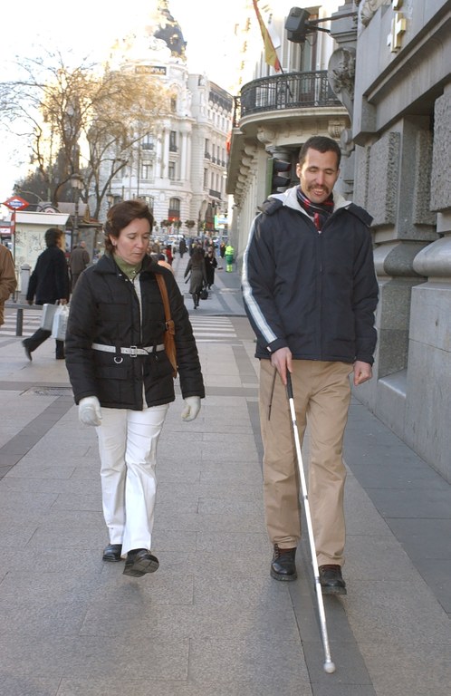Una técnico de rehabiltación y movilidad de la ONCE instruye a una persona extranjera ciega
