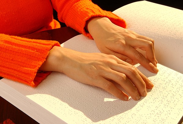 Una personas ciega leyendo braille