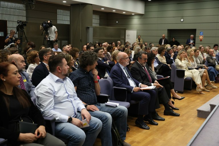 Aforo de asistentes a la jornada, con la primera fila de responsables políticos y sociales