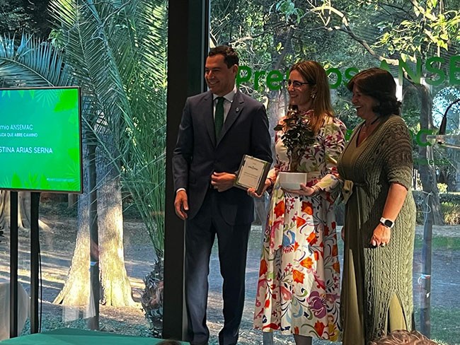 Cristina Arias, en el centro, recibe el premio de manos del presidente de la Junta de Andalucía