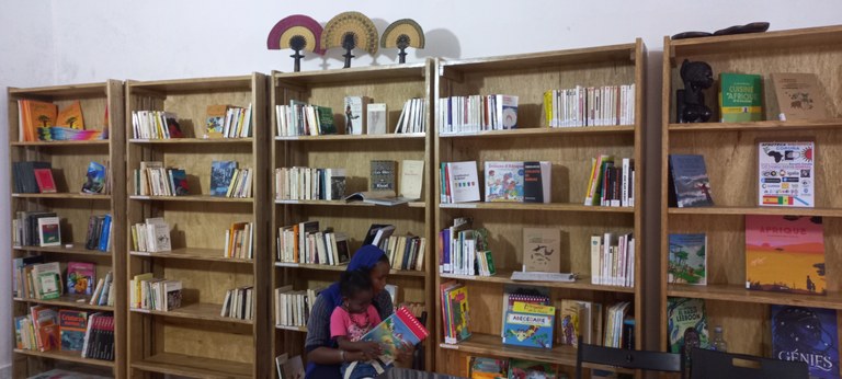 Una mujer muestra a su hijo uno de los libros de la biblioteca
