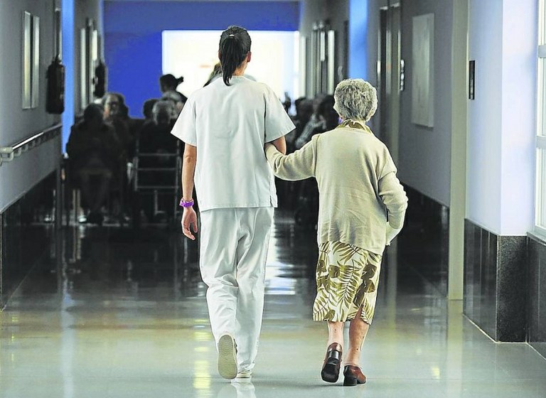 Mujer mayor junto a su cuidadora