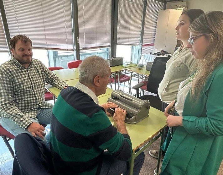 Paco Tello (izda.) y Maria José (dcha.)  junto a un afiliado mayor sordociegos en su primera clase para aprender braille, junto a una instructora de la ONCE, en la DT de la ONCE en Madrid