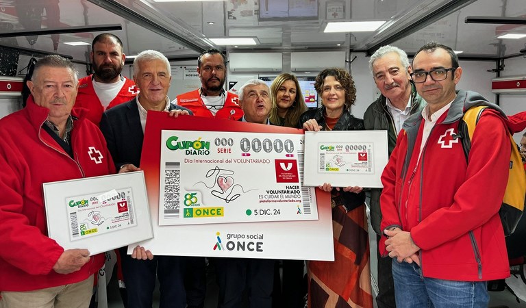 Foto de familia de los responsables de la ONCE en CV y las entidades de voluntariado con el cupón dedicado