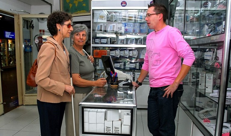 Voluntaria junto a una mujer afiliada realizando una compra en un establecimiento comercial
