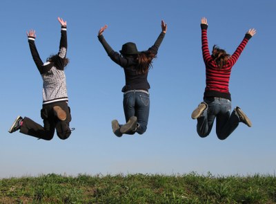 Tres jóvenes saltando en el campo