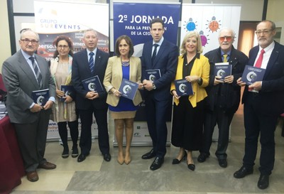 Los asistentes al acto posan con el libro recién editado