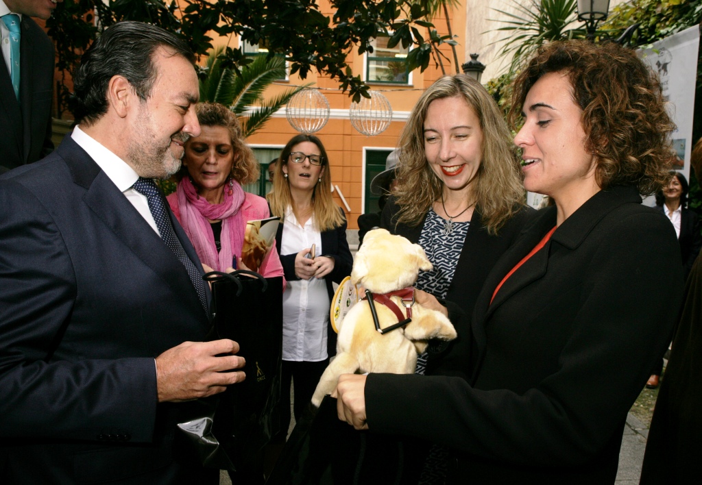 Al despedir a la ministra, el presidente de la ONCE le entrega un peluche de 'Fiel', la mascota perro guía de la FOPG