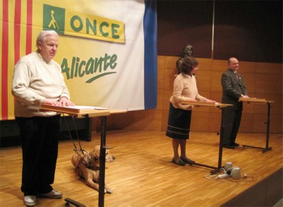 Miembros del grupo “Tomás Aznar” proceden a la lectura en braille de una serie de relatos en el  acto celebrado en Alicante con motivo del Día Mundial del Braille 2013
