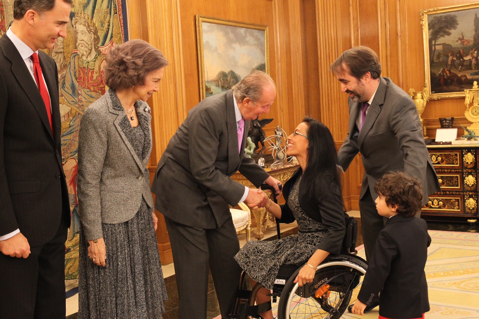 Teresa Perales, acompañada de su marido y su hijo, recibe el afectuoso saludo de el rey  Juan Carlos, acompañado ( de izquierda a derecha) por el príncipe Felipe y la reina doña Sofía.