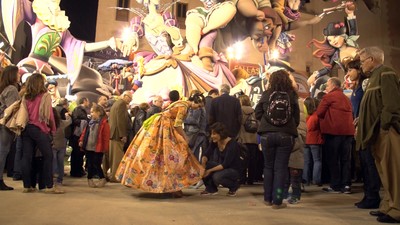 Pilar Calvo toca el vestido de una ñiña vestida de fallera en plenas fiestas valencianas