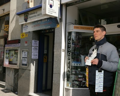 Vendedor de la ONCE junto a una administración de lotería