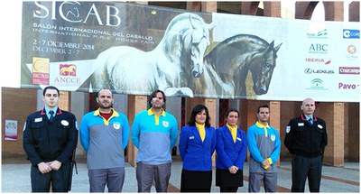 Profesionales de servicios integrales de ILUNION posan ante la entrada del Salón sevillano del Caballo de Pura Raza Española