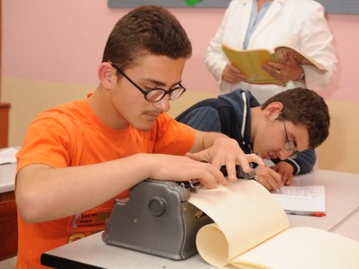 Estudiante de secundaria leyendo y escribiendo en braille