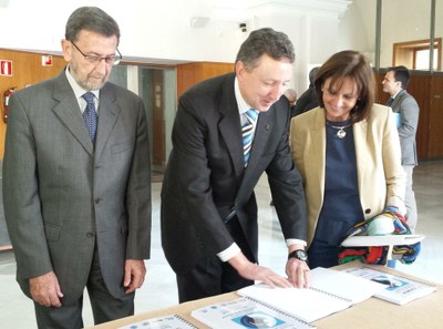 El delegado territorial de la ONCE lee en braille un folleto de la jornada de divulgación, en presencia del presidente del Parlamento andaluz, Manuel Gracia