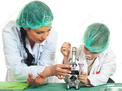 Una profesora enseña a su alumno el uso del microscopio