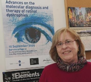 La catedrática Roser González, en la Universidad de Barcelona, junto a un cartel anunciador de unas jornadas dedicadas a distrofias de la retina