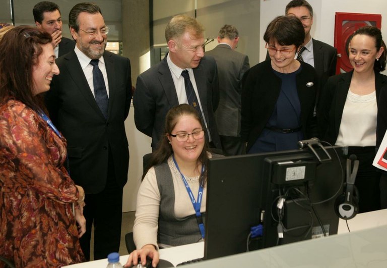 La comisaria Thyssen conversa con Natalia Esteban, empleada de ILUNION con síndrome de Down, durante su visita al centro tecnológico