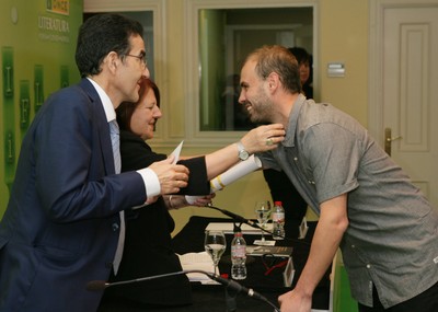 César González, ganador de Cuento, recoge su premio que le entregan Andrés Ramos y Fanny Rubio