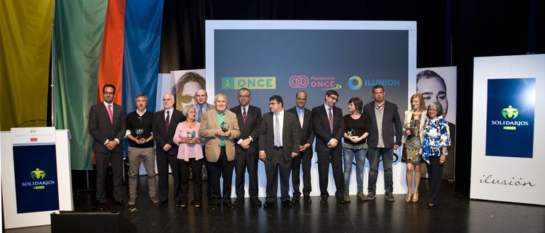 Foto de familia de premiados y autoridades sobre el escenario del Civivox Iturrama de Pamplona