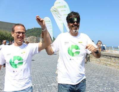 El alcalde donostiarra, Eneko Goiz, corre, provisto de un antifaz, junto al presidente del Consejo Territorial de ONCE País Vasco, Javier Domínguez
