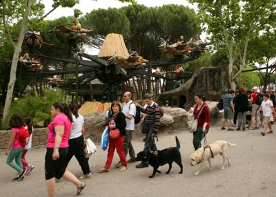 Un grupo de afiliados (algunos con su perro guía) pasean junto a sus familiares por el Parque de Atracciones de Madrid