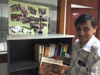 Un trabajador de ILUNION Lavanderías con un ejemplar de la biblioteca del centro de Tortosa