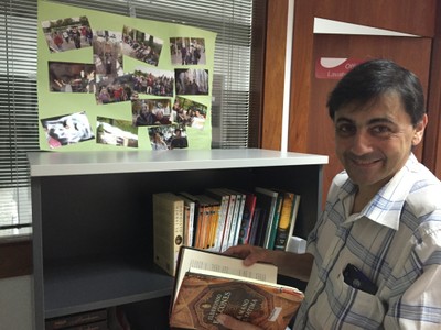 Un trabajador de ILUNION Lavanderías con un ejemplar de la biblioteca del centro de Tortosa