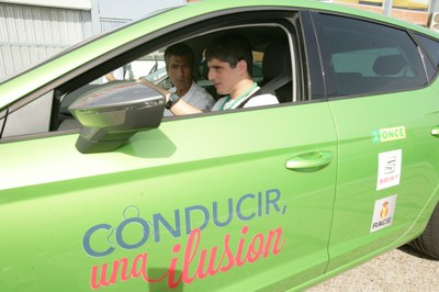 Joven afiliado, al volante, sigue las intrucciones de manejo del automóvil