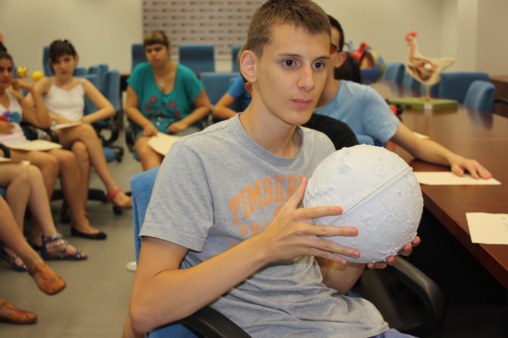 Uno de los alumnos comprueba al tacto con una maqueta el perfil y proporciones de un planeta