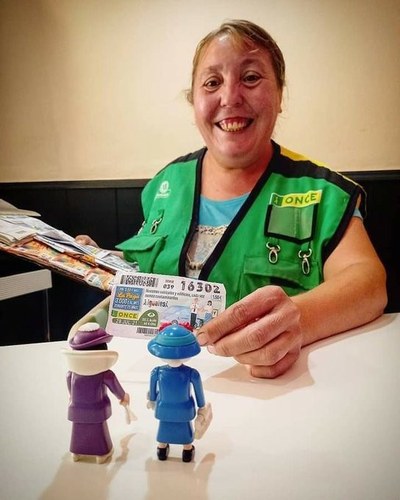 Isabel de la Rosa, con su chaleco de vendedora de la ONCE, mostrando un cupón