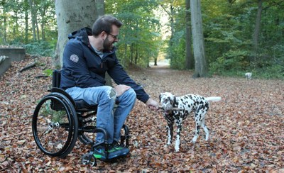 Un usuario juega en un parque con su perro desde su silla de ruedas ICON