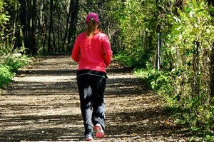 Mujer de espaldas haciendo footing en el bosque
