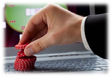 mano apostando fichas de casino en el teclado de un ordenador