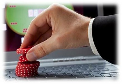 mano apostando fichas de casino en el teclado de un ordenador